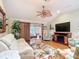 Cozy living room with hardwood floors, a fireplace, a fan and a doorway to a sunroom at 2124 Westchester Way, The Villages, FL 32162