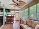 Relaxing sunroom with wicker furniture, ceiling fan, and views of the lush landscaping at 2124 Westchester Way, The Villages, FL 32162