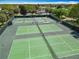 Aerial view of community tennis courts, surrounded by lush greenery and trees at 2124 Westchester Way, The Villages, FL 32162