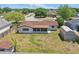 Backyard view of a single-story home featuring a screened porch and a storage shed in a spacious partially grassed yard at 2240 Archer Blvd, Orlando, FL 32833