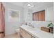 Bright bathroom featuring white fixtures, a large mirror, and clean, classic design at 2240 Archer Blvd, Orlando, FL 32833
