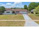 Charming single-story home with white brick, red roof, and well-maintained front lawn at 2240 Archer Blvd, Orlando, FL 32833