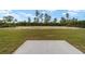 Backyard featuring a concrete patio area and a large grass lot with some trees at 23810 Sw Indian Hill Dr, Dunnellon, FL 34431