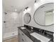 Bathroom features a white marble shower, double sink vanity with black countertop and matching framed mirrors at 23810 Sw Indian Hill Dr, Dunnellon, FL 34431