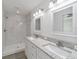 Stylish bathroom featuring a double vanity, granite countertop, marble-look walk-in shower and modern fixtures at 23810 Sw Indian Hill Dr, Dunnellon, FL 34431