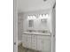 Bathroom with double sink vanity, granite countertop, and walk-in shower with marble-look tile at 23810 Sw Indian Hill Dr, Dunnellon, FL 34431