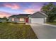 Charming single-story home boasts a fresh exterior, attached garage and newly installed lawn at 23810 Sw Indian Hill Dr, Dunnellon, FL 34431