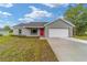 Charming single-story home boasts a fresh exterior, attached garage and newly installed lawn at 23810 Sw Indian Hill Dr, Dunnellon, FL 34431