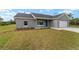 Single-story home with a well-manicured lawn, fresh landscaping, and a two-car garage at 23810 Sw Indian Hill Dr, Dunnellon, FL 34431