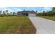 Single-story home with a well-maintained lawn and a long driveway leading to a two-car garage at 23810 Sw Indian Hill Dr, Dunnellon, FL 34431