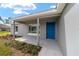 Inviting front porch with a bright blue door and manicured landscaping at 23810 Sw Indian Hill Dr, Dunnellon, FL 34431