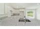 Bright kitchen features white cabinets, granite countertops, and stainless steel sink overlooking the backyard at 23810 Sw Indian Hill Dr, Dunnellon, FL 34431