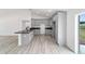 Open kitchen features gray cabinets, black countertops, stainless appliances, and wood-look flooring at 23810 Sw Indian Hill Dr, Dunnellon, FL 34431