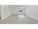 Bright living room with gray floors, white walls, a front door, and a large window at 23810 Sw Indian Hill Dr, Dunnellon, FL 34431