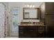 Well-lit bathroom with dark vanity, marble countertop, framed mirror, and tile flooring at 257 Donegal Ct, Altamonte Springs, FL 32714