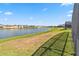 A vast backyard stretches towards a serene lake, framed by lush green grass with a view of other homes at 2723 Callaway Ln, Kissimmee, FL 34744