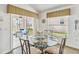 Dining area with a glass-top table and view of a screened-in patio and backyard at 2723 Callaway Ln, Kissimmee, FL 34744