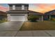 Charming two-story home featuring a two-car garage, well-maintained lawn and beautiful sky at 2723 Callaway Ln, Kissimmee, FL 34744