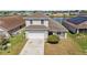 Exterior of home with well-kept lawn, two-car garage, complemented by a backdrop of a beautiful lake at 2723 Callaway Ln, Kissimmee, FL 34744