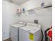 Convenient laundry room with washer, dryer, and storage shelf at 2723 Callaway Ln, Kissimmee, FL 34744