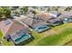 Aerial view of backyard pools, enclosed by screen, on a sunny day in a residential community at 2723 Callaway Ln, Kissimmee, FL 34744