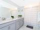 Bright bathroom featuring double sinks, gray vanity, and a shower-tub combination, offering a clean and modern space at 2964 Protagonist St, Kissimmee, FL 34746