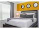 Comfortable bedroom features a queen bed with a soft gray throw and a yellow accent wall at 2964 Protagonist St, Kissimmee, FL 34746
