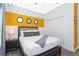 Comfortable bedroom features a queen bed with a closet and a yellow accent wall at 2964 Protagonist St, Kissimmee, FL 34746