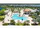 An aerial view shows the large community pool with a snack bar, splash pad, and lounge chairs at 2964 Protagonist St, Kissimmee, FL 34746