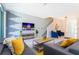 Open-concept living area with a gray sofa, accent pillows, and a flat-screen TV, creating a welcoming and stylish space at 2964 Protagonist St, Kissimmee, FL 34746