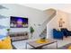 Bright living room boasts modern decor and an entertainment area with a large-screen television and stairs at 2964 Protagonist St, Kissimmee, FL 34746