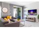 Modern living room with a stylish sectional sofa, wall decor and television at 2964 Protagonist St, Kissimmee, FL 34746