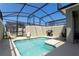 Private screened-in pool area with lounge chairs and outdoor grilling space at 2964 Protagonist St, Kissimmee, FL 34746