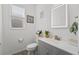 Modern half bathroom with a sleek vanity, decorative mirror, and bright natural light from a large window at 3087 Somerset Park Dr, Orlando, FL 32824
