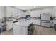 Bright kitchen features an island with seating, white cabinets and stainless steel appliances at 3087 Somerset Park Dr, Orlando, FL 32824