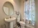 Cozy bathroom featuring pedestal sink, toilet, and nautical-themed shower curtain at 3954 Great Smokey Way, Apopka, FL 32712