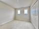 Empty bedroom with neutral walls, carpet flooring, two windows, and closet with bi-fold doors at 3954 Great Smokey Way, Apopka, FL 32712