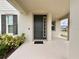 Covered front porch with a dark front door and lovely landscaping at 3954 Great Smokey Way, Apopka, FL 32712