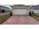 A paver driveway leads up to a two-car garage, complemented by manicured shrubbery on either side at 3954 Great Smokey Way, Apopka, FL 32712
