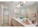 Well-lit bathroom featuring dual sinks and a shower with floral wallpaper at 420 Wild Oak Cir, Longwood, FL 32779