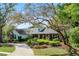 Beautiful home with mature trees, lush landscaping, a brick driveway and walkway leading to the front entrance at 420 Wild Oak Cir, Longwood, FL 32779