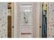 Hallway view toward a bathroom with floral wallpaper and a sink vanity between two bedroom closets at 420 Wild Oak Cir, Longwood, FL 32779