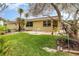 Inviting backyard featuring a lush lawn, tropical plants, brick patio, and mature trees at 4231 Yorketowne Rd, Orlando, FL 32812