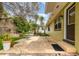 Side of house featuring a stone patio with tropical plants and lush landscaping at 4231 Yorketowne Rd, Orlando, FL 32812