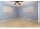 Spacious bedroom features neutral carpet, a ceiling fan, light blue walls, and two large windows at 4231 Yorketowne Rd, Orlando, FL 32812