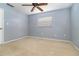 Empty bedroom with light blue walls, neutral carpet, a ceiling fan, and a window at 4231 Yorketowne Rd, Orlando, FL 32812
