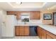 Traditional kitchen design featuring wood cabinets, white countertops, tile backsplash, and a black dishwasher at 4231 Yorketowne Rd, Orlando, FL 32812