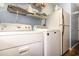 Bright laundry area featuring a white washer, dryer, and ample shelf storage at 4231 Yorketowne Rd, Orlando, FL 32812