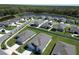 Aerial view of a neighborhood, highlighting the homes and surrounding pond at 4316 Carrabelle River Ln, Lakeland, FL 33811