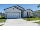 Charming single-story home features a two-car garage, a well-manicured lawn, and a concrete driveway at 4316 Carrabelle River Ln, Lakeland, FL 33811
